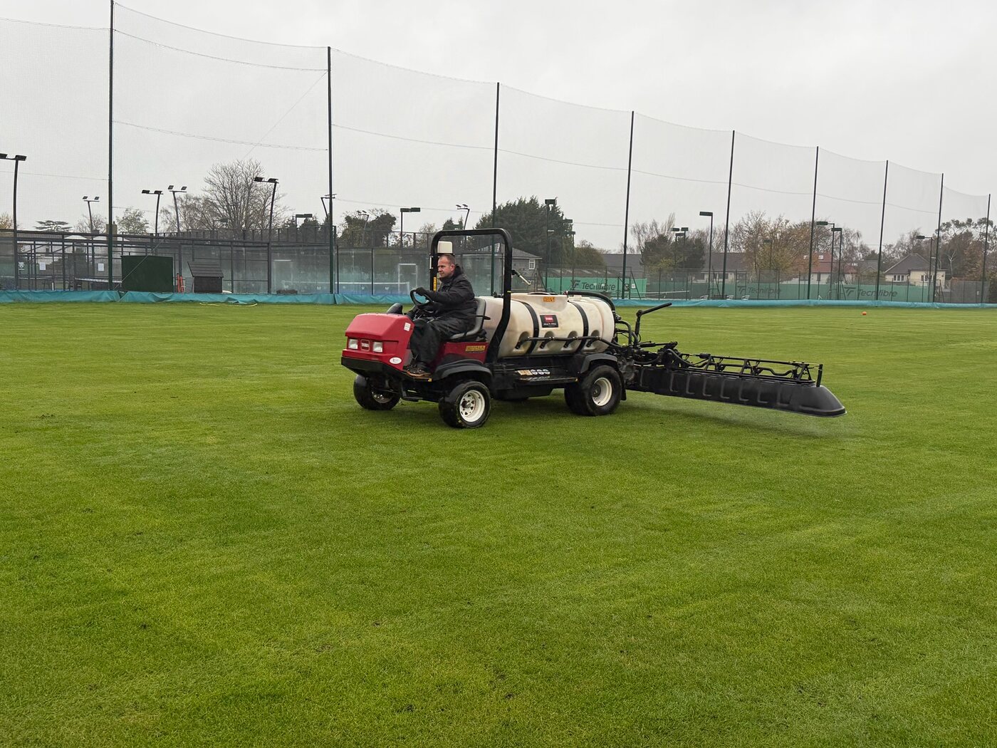 Toro sprayer applying treatment across a sports pitch with the boom extended